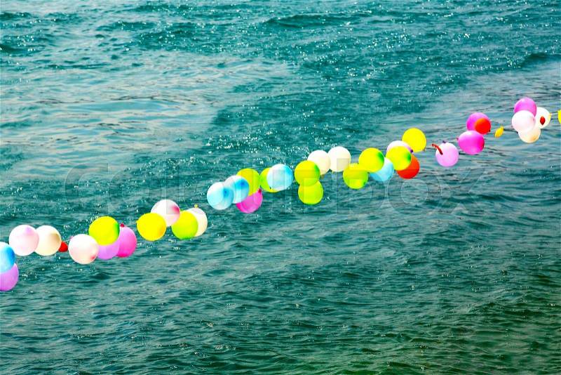 Colorful balloons on the water are placed in a row, stock photo