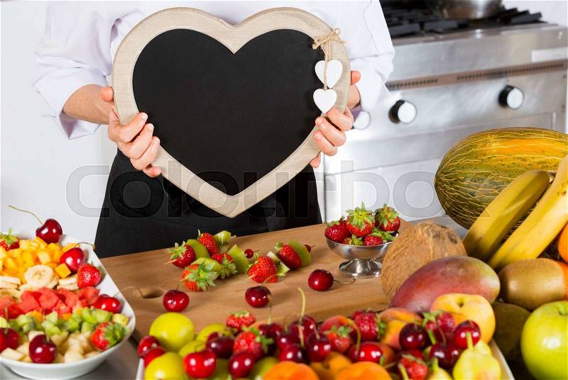 Chef with a blackboard in the form of heart, stock photo