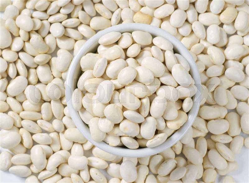 Close up of raw white beans in white bowl, stock photo