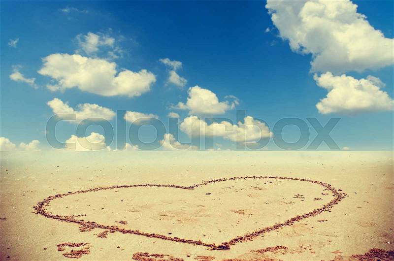 Heart drawn on sand of thailand beach with blue sky, stock photo