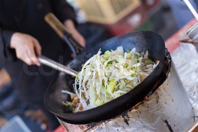 Cheff cooking traditional Thai noodles, Pad Thai, on street stall on international street food festival of Odprta kuhna, Open kitchen event, in Ljubljana, Slovenia, stock photo