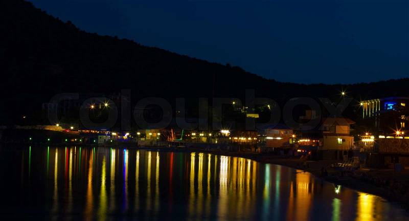 Brightly lit with colored lights at night embankment New World settlement, Crimea, Ukraine, stock photo