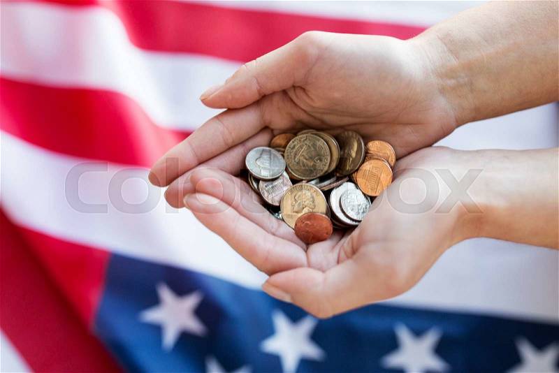 Finances, money, crisis, investment and state budget concept - close up of hands with coins over american flag, stock photo