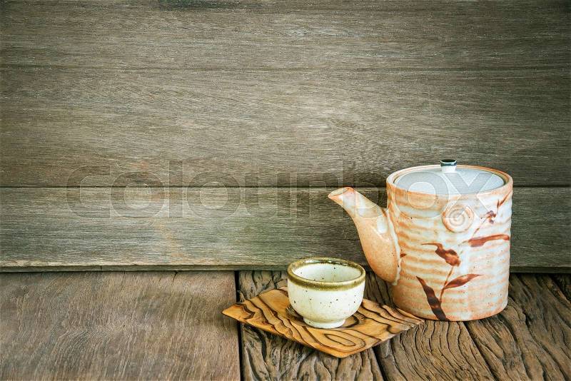 Still life of set of japanese ceramic teapot and cup on wooden texture background, stock photo