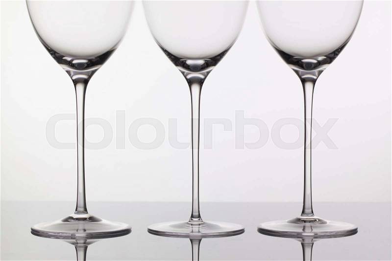 Three empty glasses of wine on a clean background, stock photo