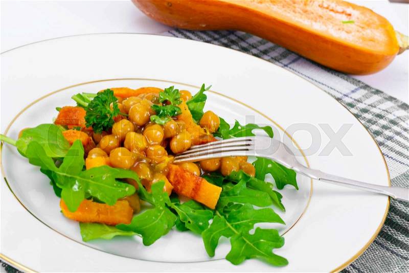 Salad with Chickpeas in a Curry Sauce, Arugula, Grilled Pumpkin and Cherry Tomato Studio Photo, stock photo