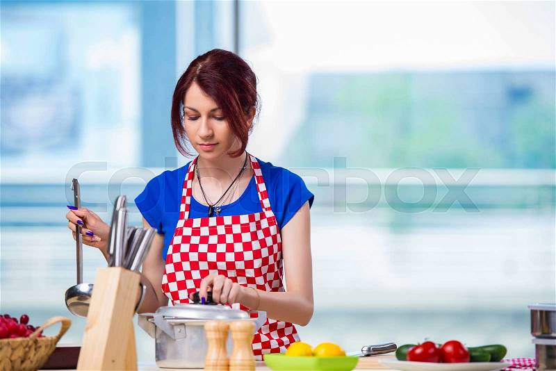 Young cook working in the kitchen, stock photo
