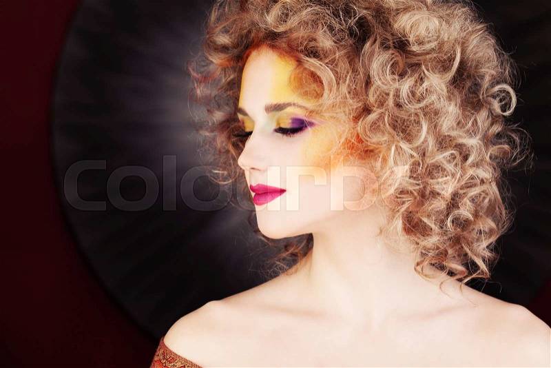 Glamorous Woman. Fashion Makeup and Blonde Curly Hair, stock photo