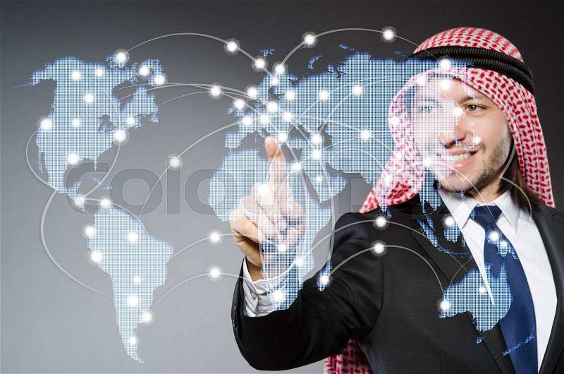 Arab man pressing dots on world map in global communication concept, stock photo