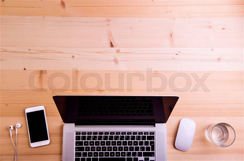 Desk with gadgets and office supplies. Laptop, smart phone and office stuff around the workplace. Flat lay. Studio shot on wooden background. Copy space, stock photo