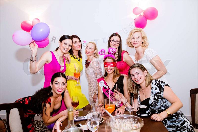 Cheerful bride and happy bridesmaids celebrating hen party with drinks. Women enjoying a bachelorette party, stock photo