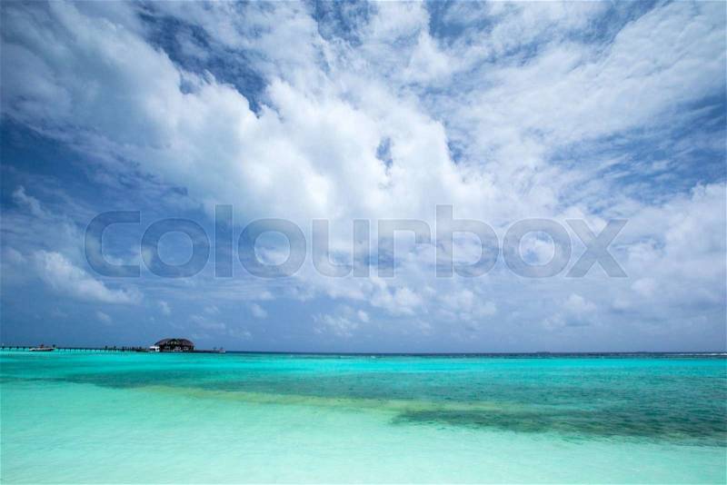 Tropical beach in Maldives with few palm trees and blue lagoon, stock photo