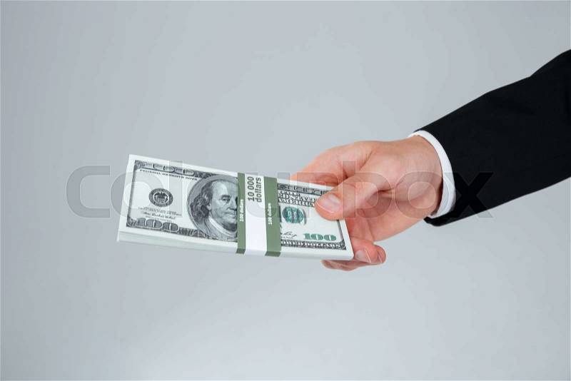 Hand of businessman in suit holding money, stock photo