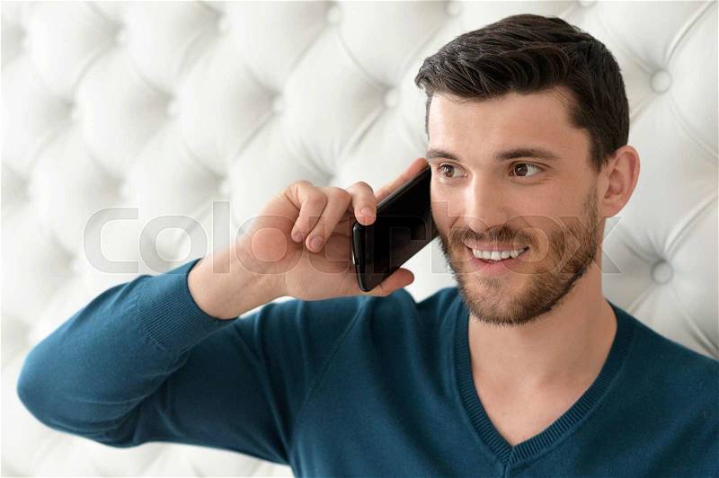 Portrait of a young man speaking on the phone, stock photo