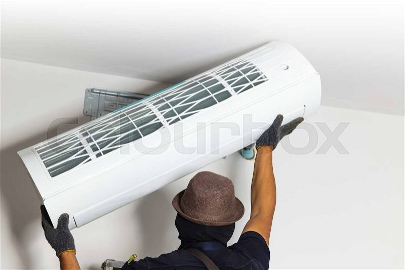 Technician air conditioning setup and installs the new air conditioner in new home, stock photo
