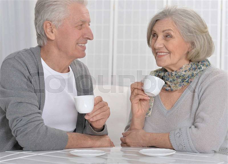 Portrait of a happy senior couple drinking tea, stock photo
