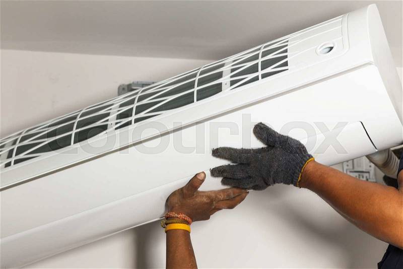 Technician air conditioning setup and installs the new air conditioner in new home, stock photo