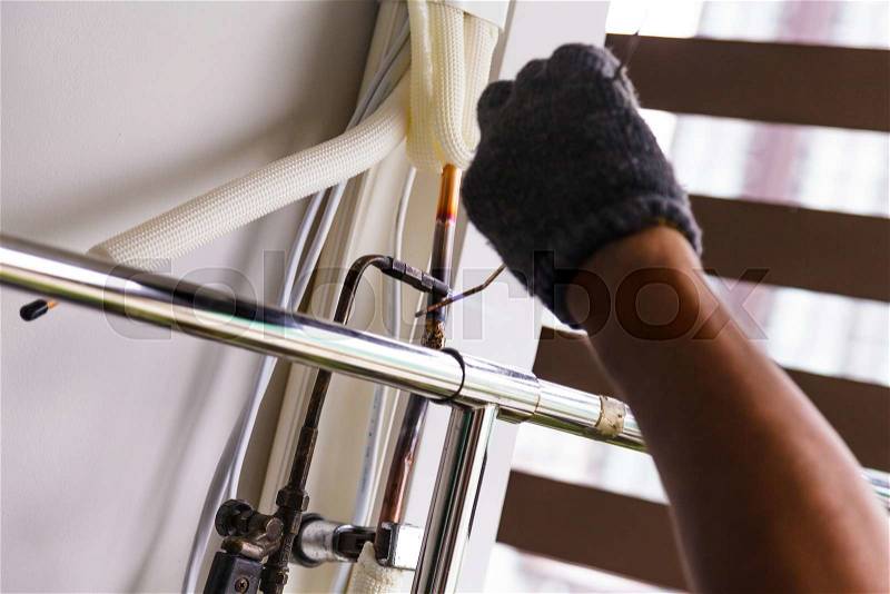 Worker the air conditioner pipe welding gas torch to solder copper, stock photo