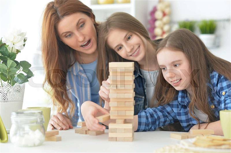 Happy Family at the table playing board game, stock photo