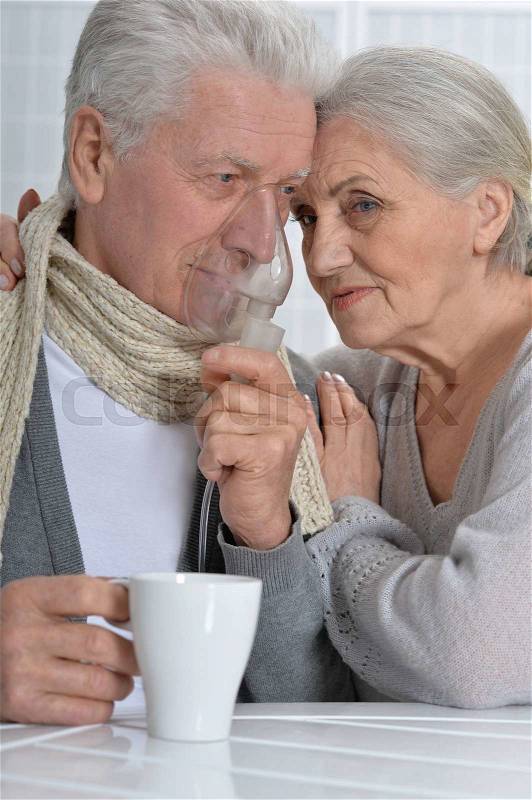 Portrait of a ill senior couple portrait with inhaler, stock photo