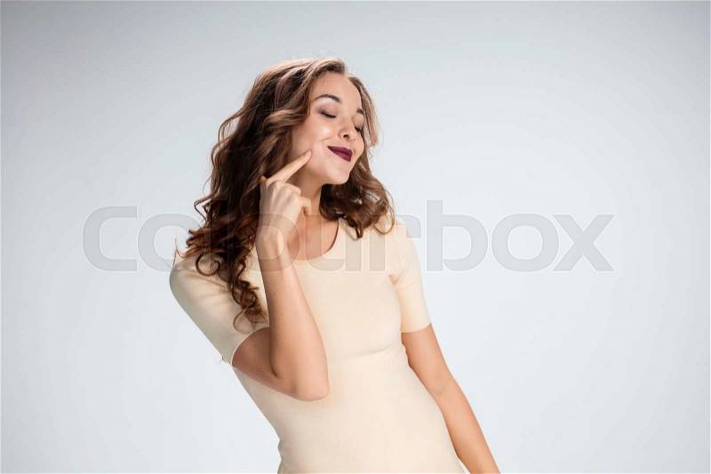 The young woman\'s portrait with love happy emotions on gray background, stock photo