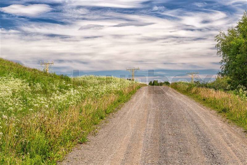 Gravel Road and Approach Lighting System with a cloudy sky, stock photo