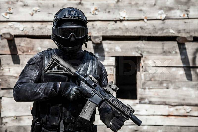 Spec ops police officer SWAT in black uniform in action, stock photo