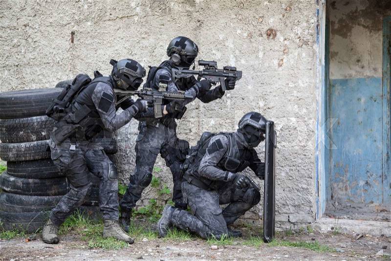 Spec ops police officers SWAT in black uniform in action, stock photo