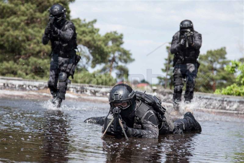 Spec ops police officers SWAT in action in the water, stock photo