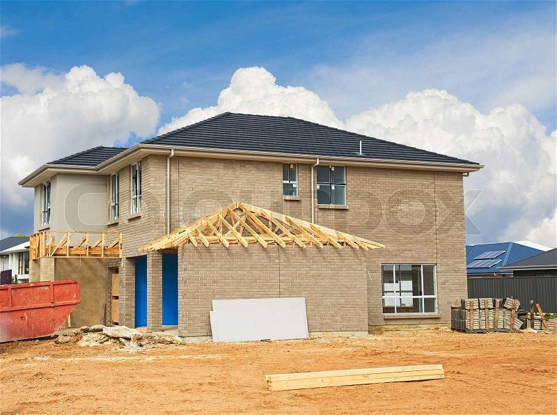New home currently under construction against blue sky, stock photo