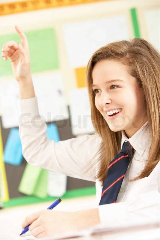 Teenage Female Student Answering Question In Classroom, stock photo