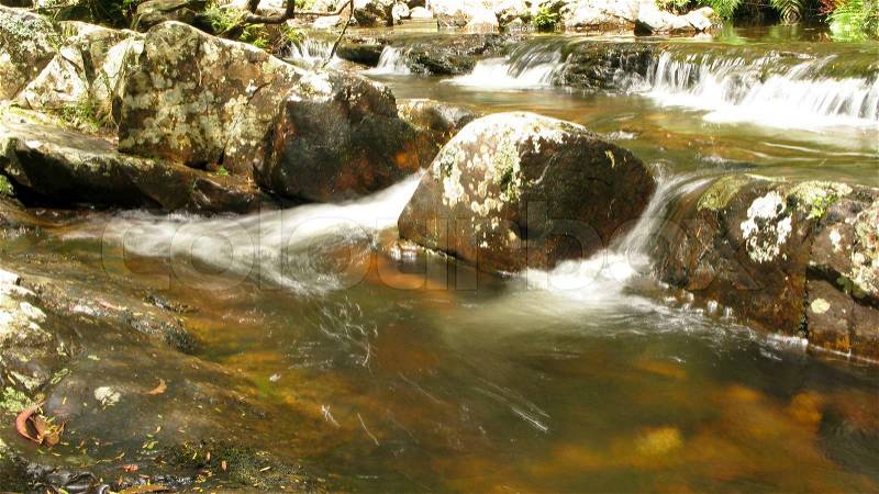 Water flow around stones in a small river in australia, water fall, stock photo