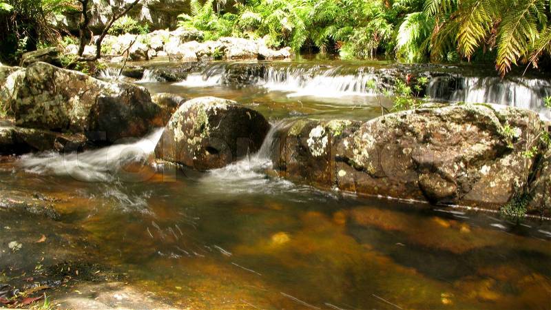Water flow around stones in a small river in australia, water fall, stock photo