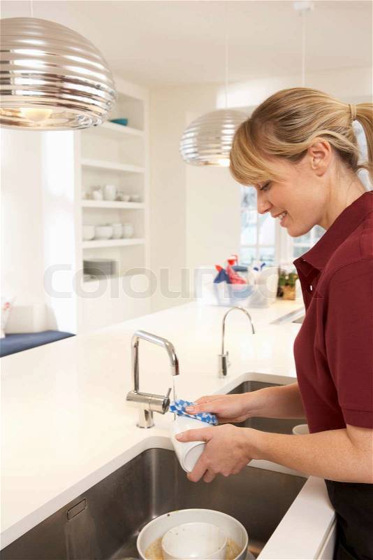 Cleaner Working In Domestic Kitchen, stock photo