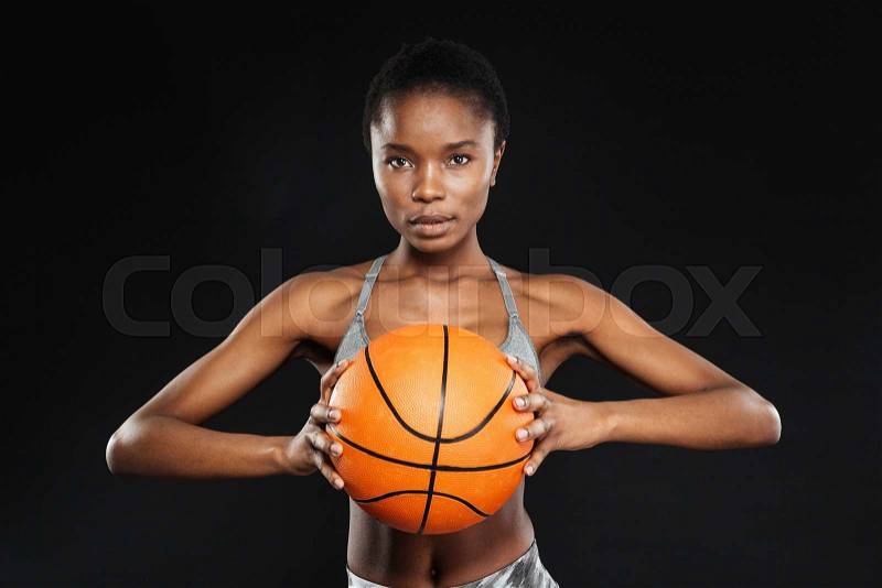 Beautiful female basketball player isolated over a black background, stock photo