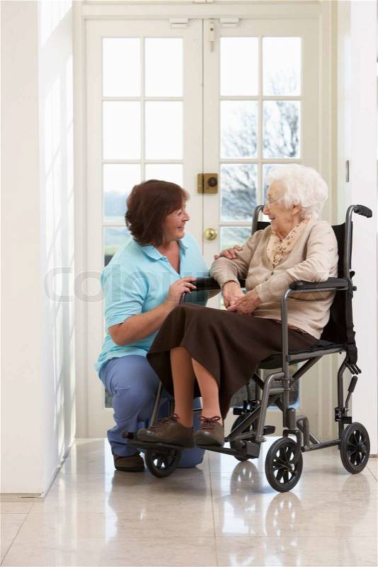 Carer With Disabled Senior Woman Sitting In Wheelchair, stock photo