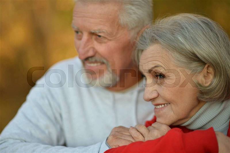 Happy fit senior couple in autumn park, stock photo