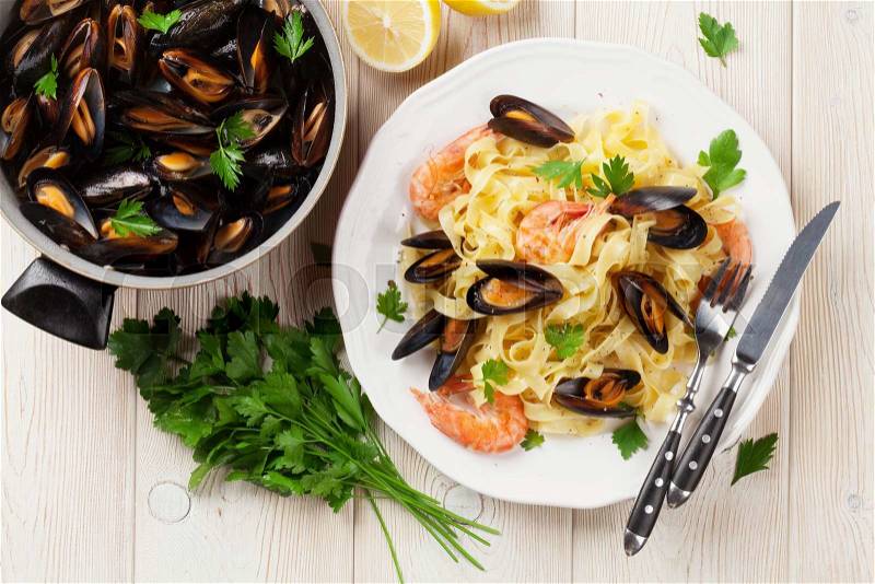 Pasta with seafood on wooden table. Mussels and prawns. Top view, stock photo