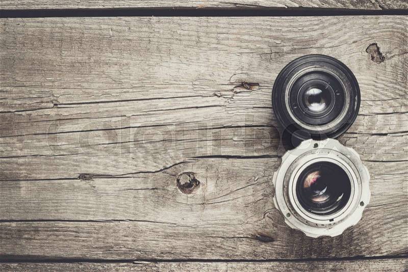 Retro camera lenses on the wooden table, stock photo