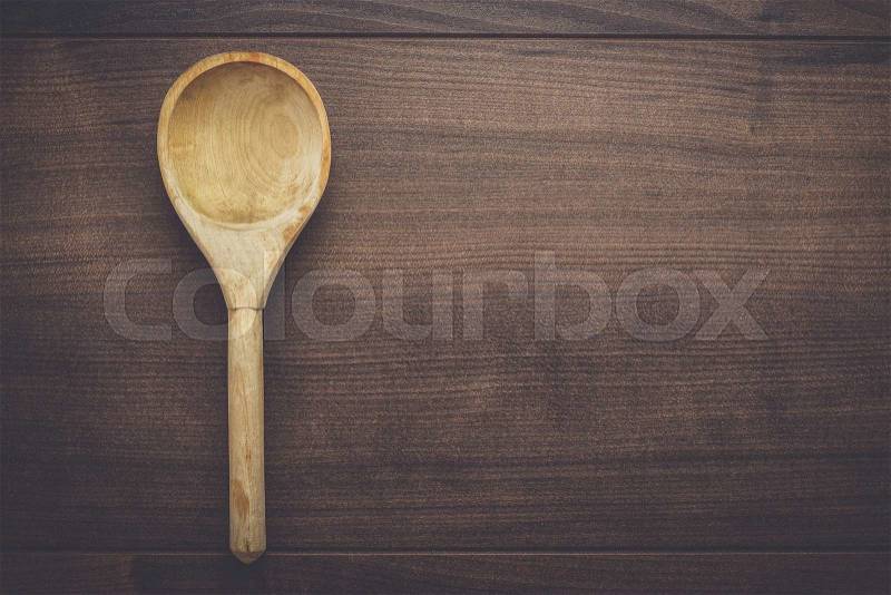 Old wooden spoon on the blue table, stock photo