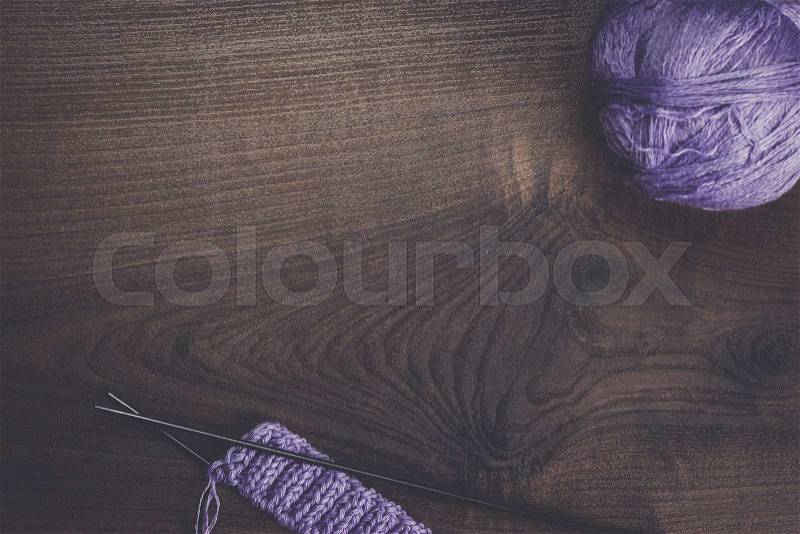 Knitting needles and balls of threads on wooden background, stock photo