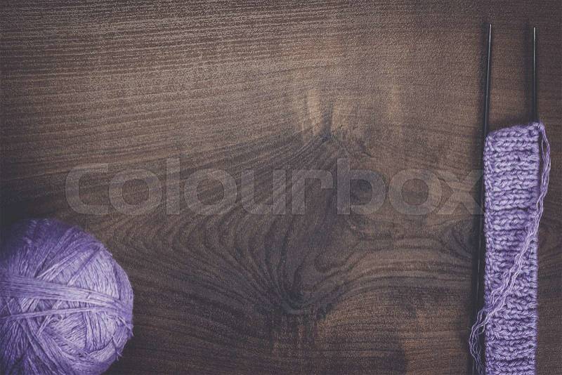 Knitting needles and ball of threads on wooden background, stock photo