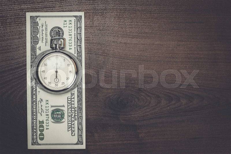 Time and money concept on wooden background, stock photo