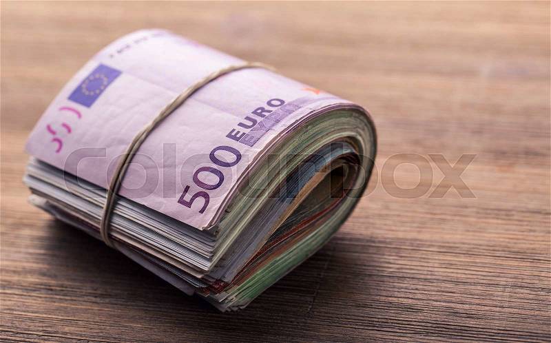 Euro banknotes. Euro currency. Euro money. Close-up Of A Rolled Euro Banknotes On Wooden table, stock photo