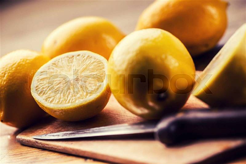 Yellow lemons. Lemons cut into the old kitchen board with mint leaves, stock photo