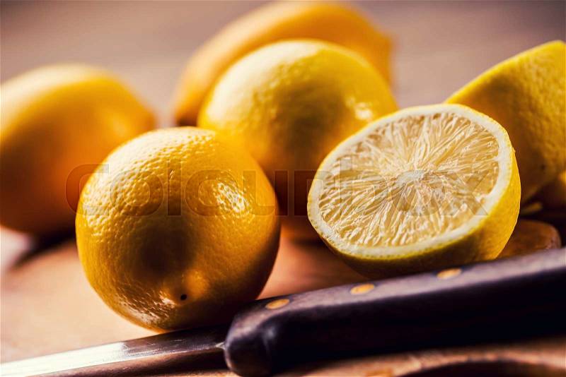 Yellow lemons. Lemons cut into the old kitchen board with mint leaves, stock photo