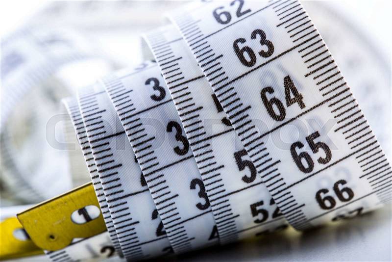 Curved measuring tape. Measuring tape of the tailor. Closeup view of white measuring tape, stock photo