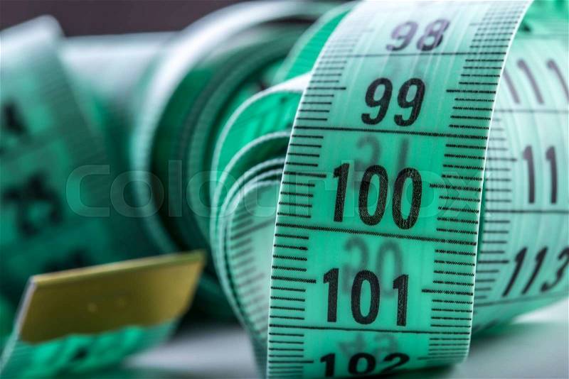 Curved measuring tape. Measuring tape of the tailor. Closeup view of Green measuring tape, stock photo