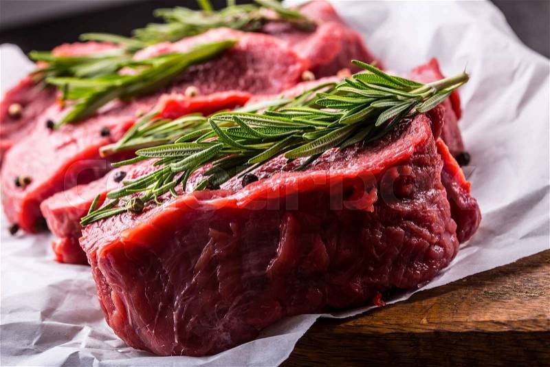 Steak. Raw beef steak. Fresh raw Sirloin beef steak sliced or whole ready for BBQ or grill. Herb - Rosemary decoration, stock photo