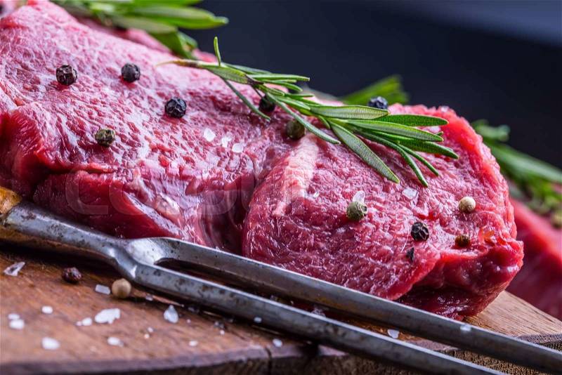 Steak. Raw beef steak. Fresh raw Sirloin beef steak sliced or whole ready for BBQ or grill. Herb - Rosemary decoration, stock photo